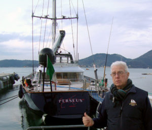 Ron Holland stands at stern of Perseus^3 Perini Navi Shipyards, Pisa Italy