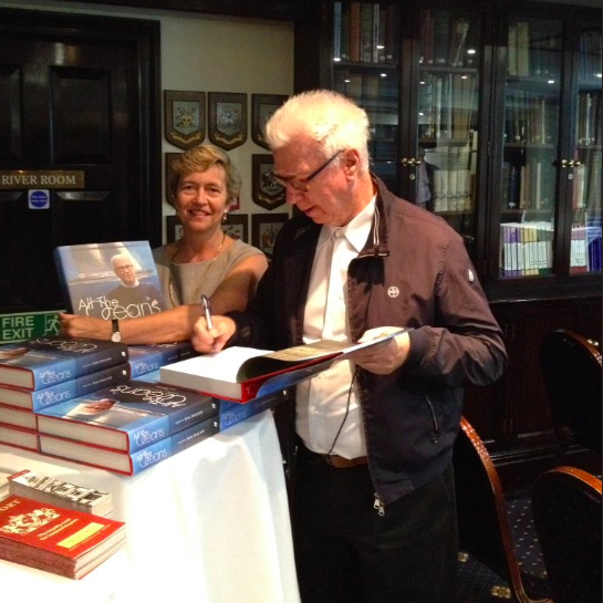 Ron Holland signs copy of his book "All The Oceans" for library of Little Ship Club London, Vivien Godfrey of Stanfords Books and Charts is lending a helping hand