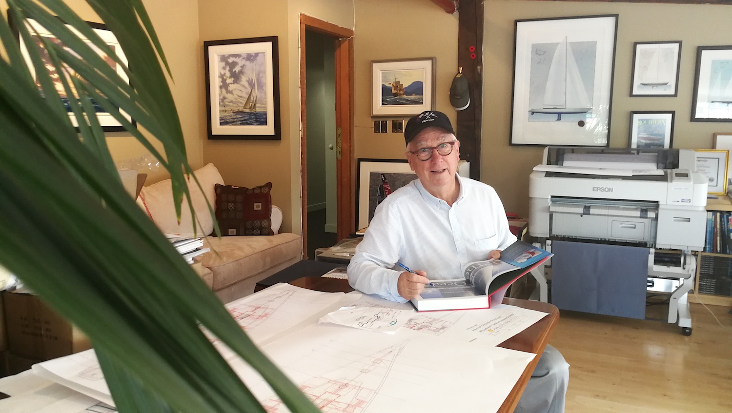 Ron Holland at the Ron Holland Design office, signing a copy of his memoir All The Oceans