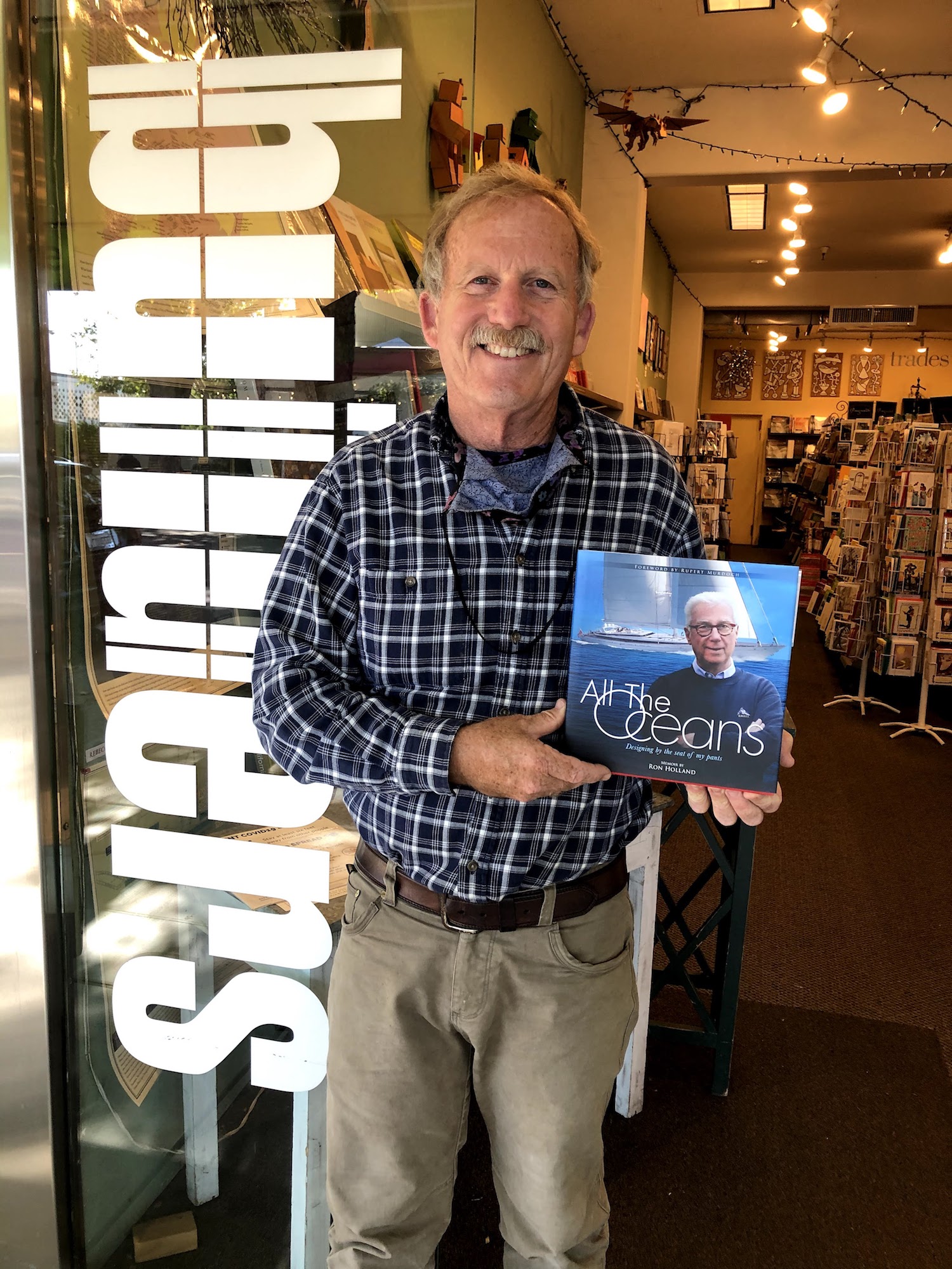 George Kiskaddon with a copy of Ron Holland's All The Oceans at his Builders Booksource shop in Berkley CA