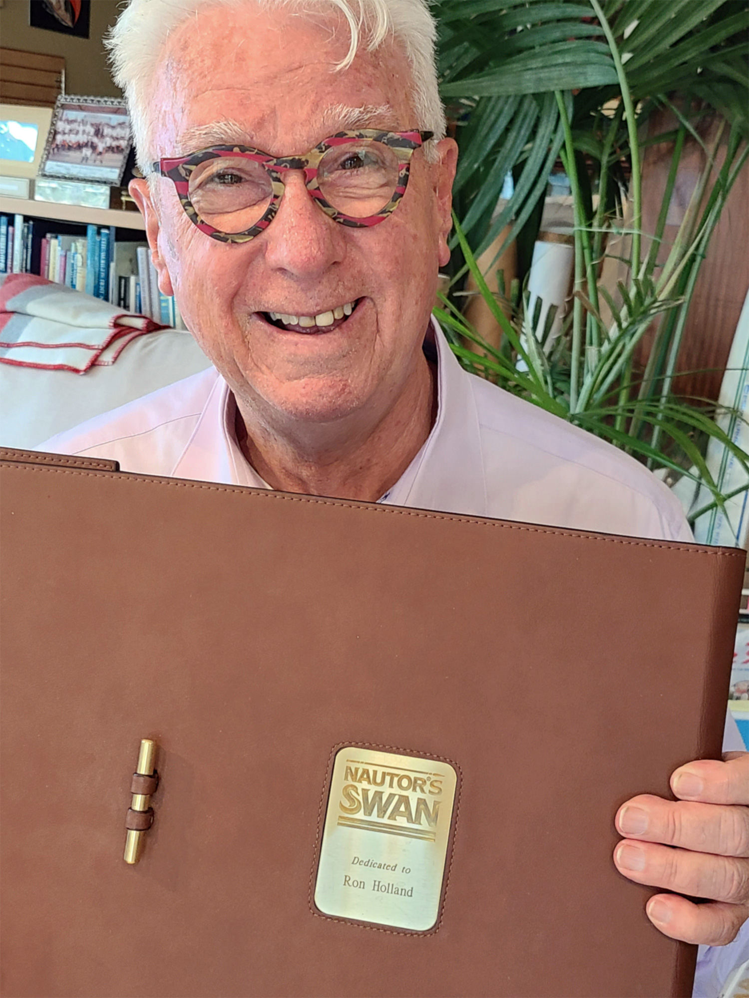 Ron Holland holds gift from Leonardo Ferragamo, a leather bound copy of the special Swan 50 Years of Yachting Evolution book